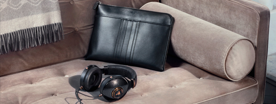 Bentley headphones on sofa with leather bag in background